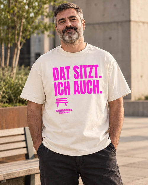 DAT SITZT. ICH AUCH. – Neonmotiv an einem fiktiven Model bei Tageslicht. KI-Produktillustration.